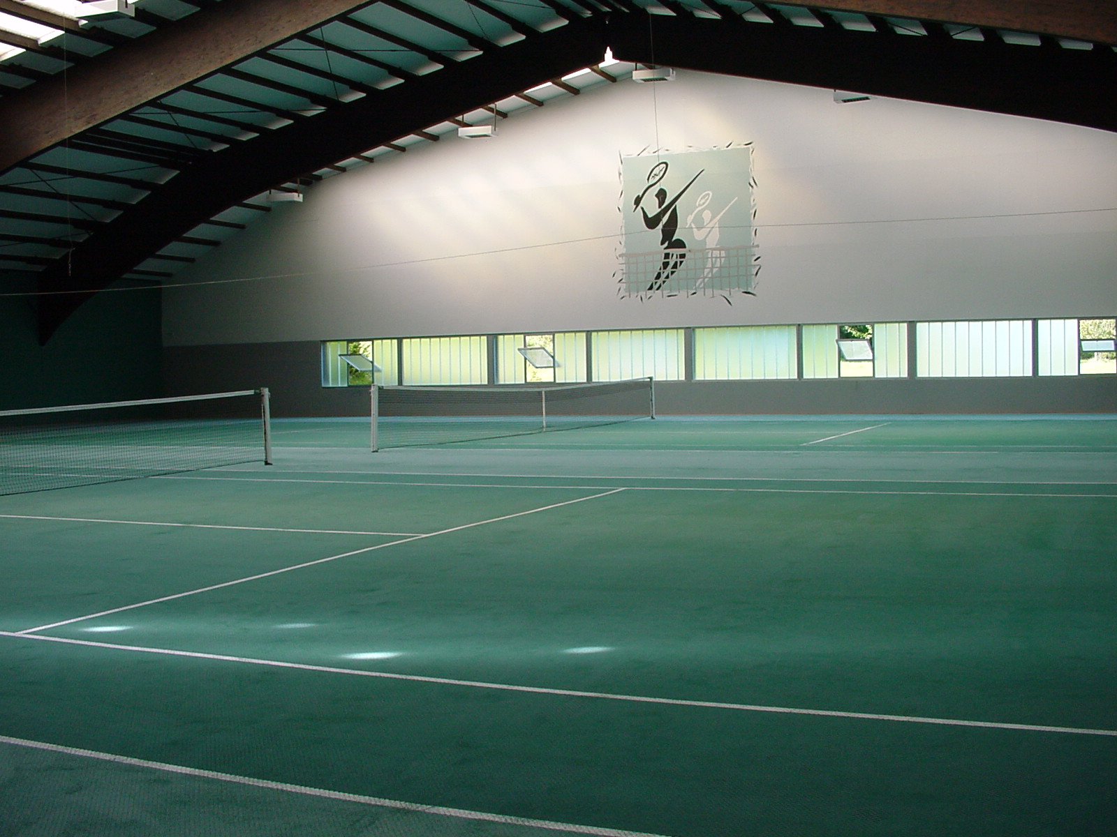 Blick in die 2-Feld-Tennishalle Westerheim mit Vereinslogo an der Wand
